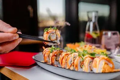 Sushi mit Stäbchen am gedeckten Tisch im ra’mien go